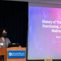 Scholar wearing mask and presenting slideshow presentation.